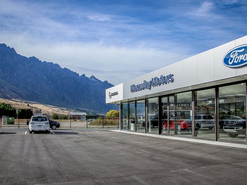 Glazed sectional doors installed at Macaulay Motors Ford dealership showroom.
